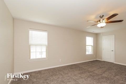a living room with carpet and a ceiling fan