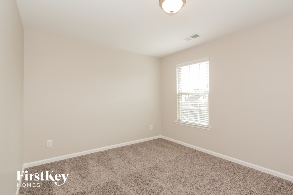 a bedroom with a carpeted floor and a window