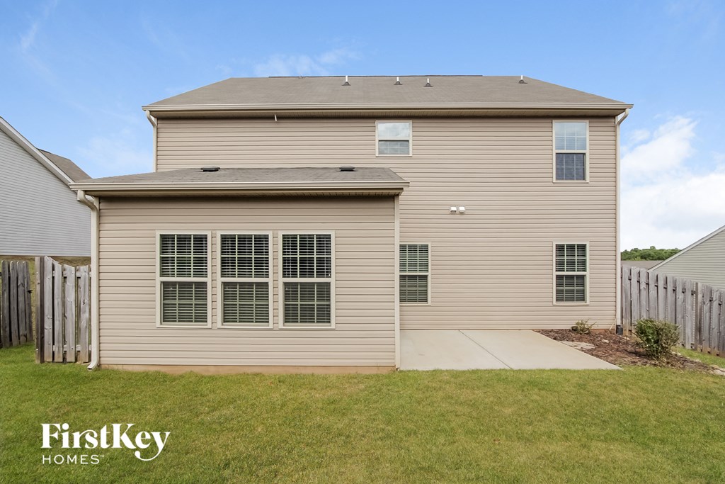 the front of a tan house with a white sidewalk