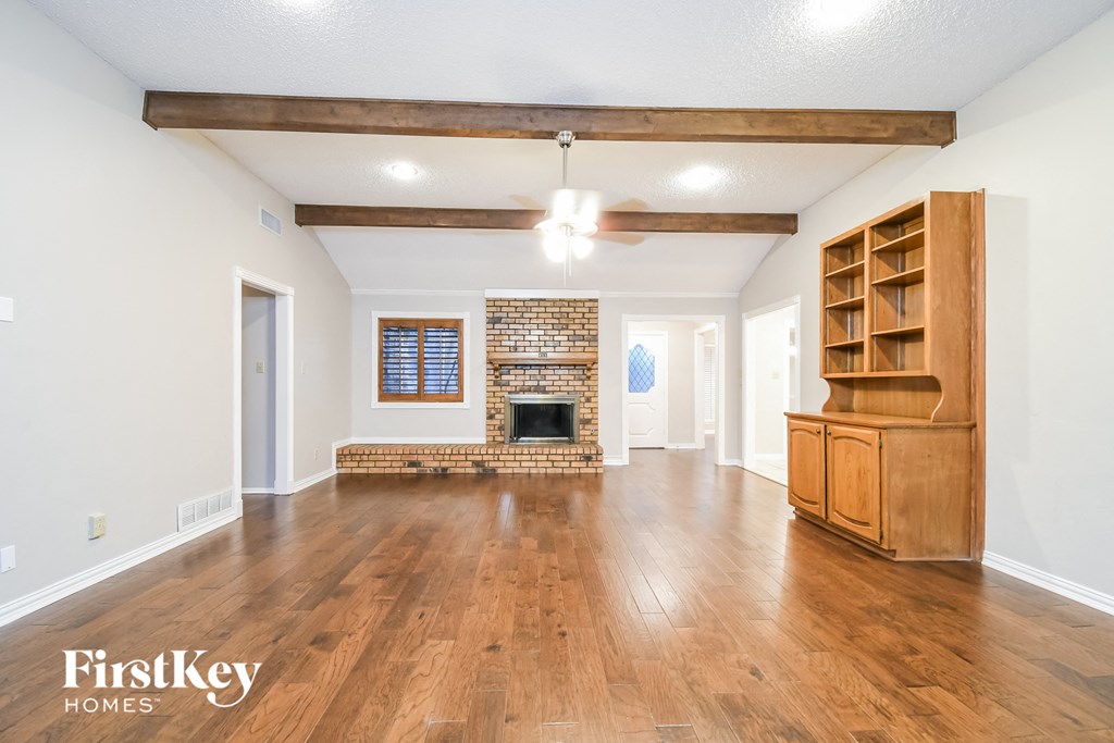 a living room with a fireplace and wooden floors