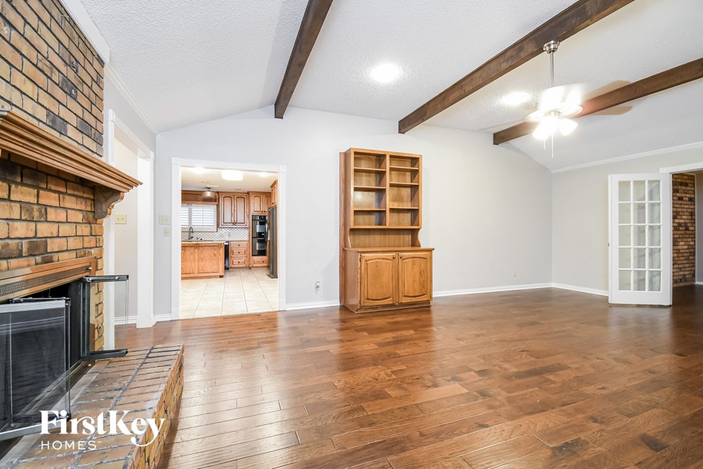 a living room with a fireplace and a hard wood floor