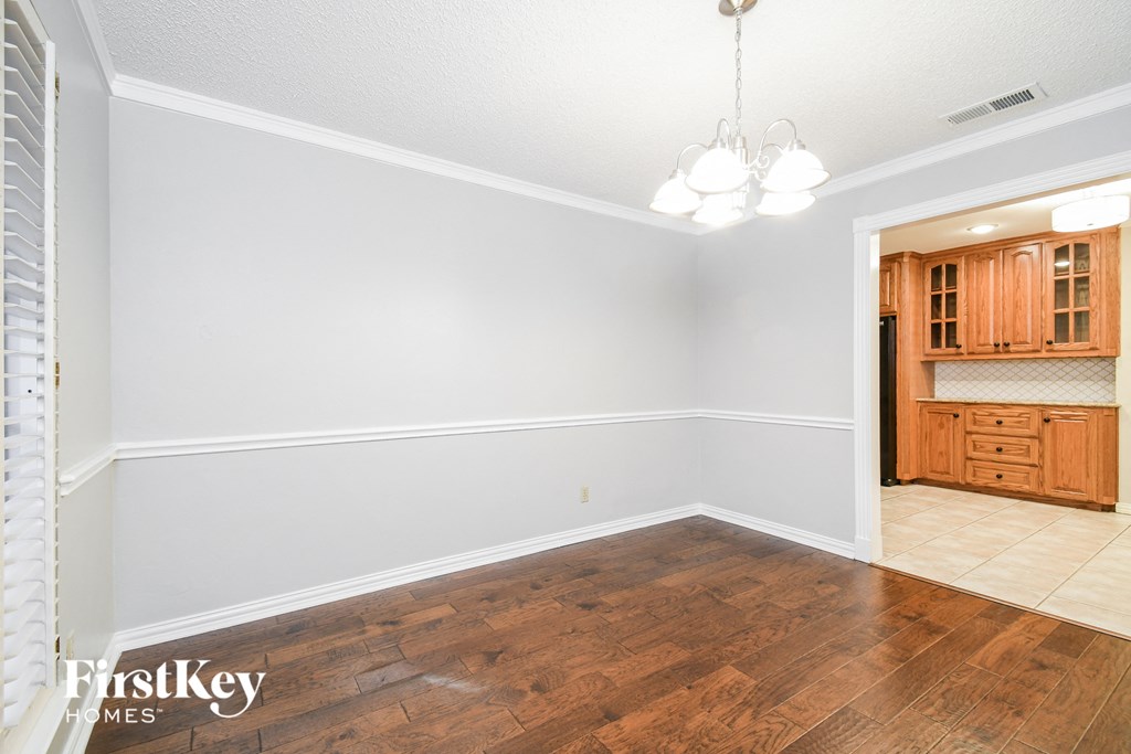a dining room with wood flooring and white walls