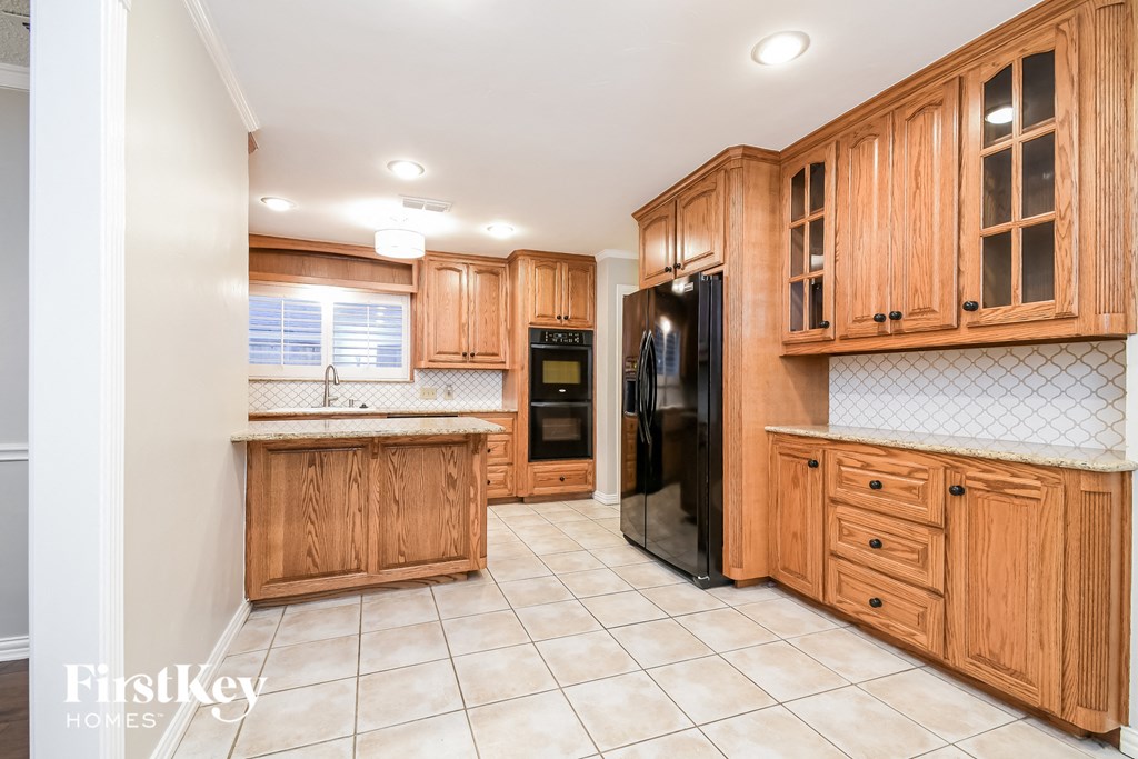 a kitchen with wooden cabinets and a black refrigerator