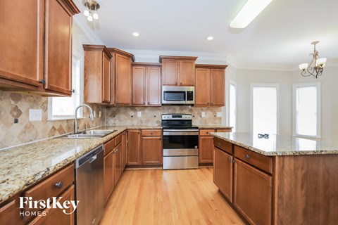 A kitchen with wooden cabinets and a granite countertop.