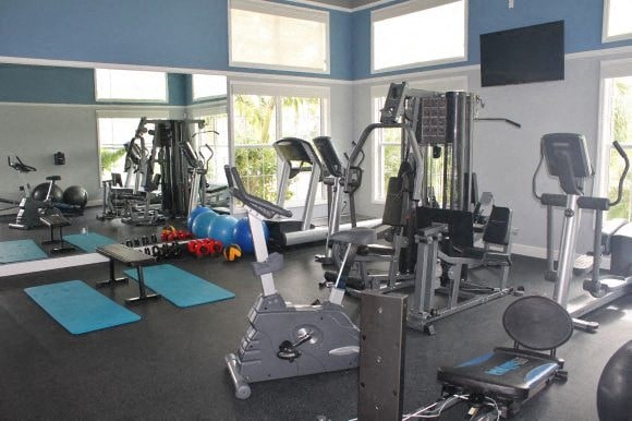 a gym with a lot of exercise equipment and windows