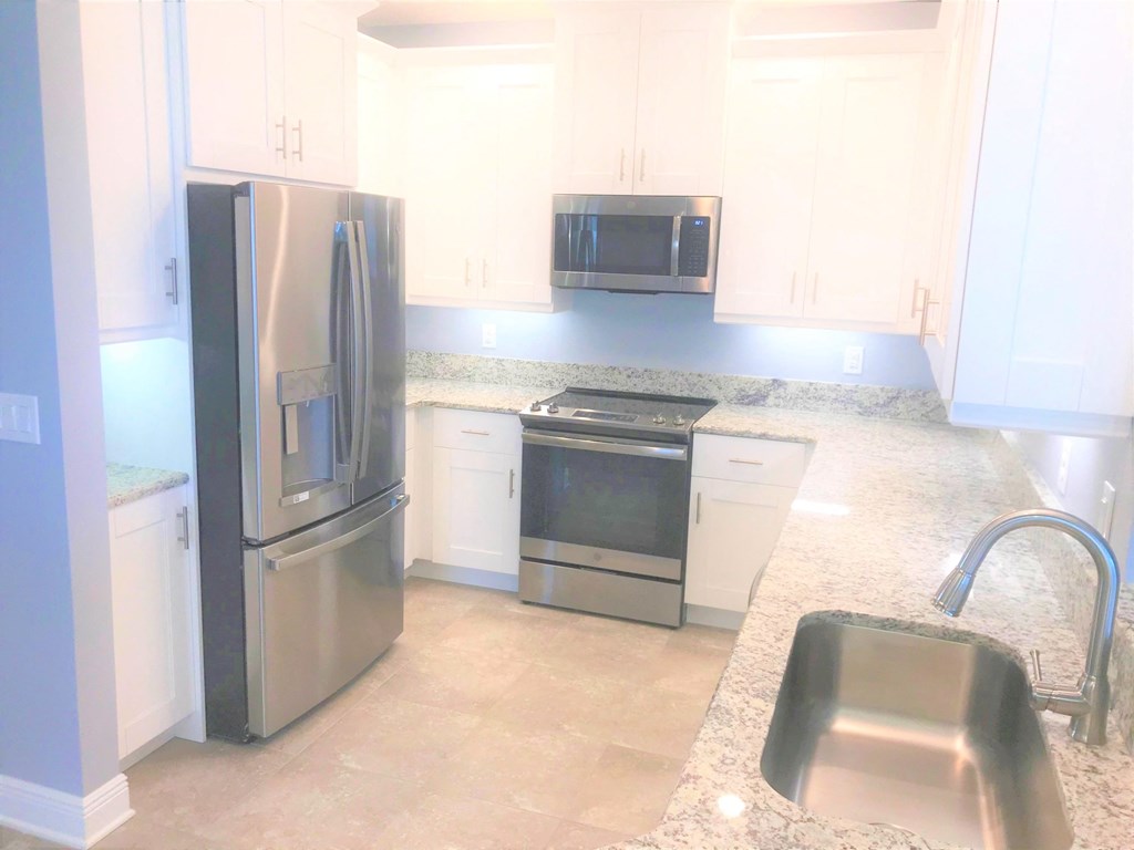 a kitchen with stainless steel appliances and white cabinets