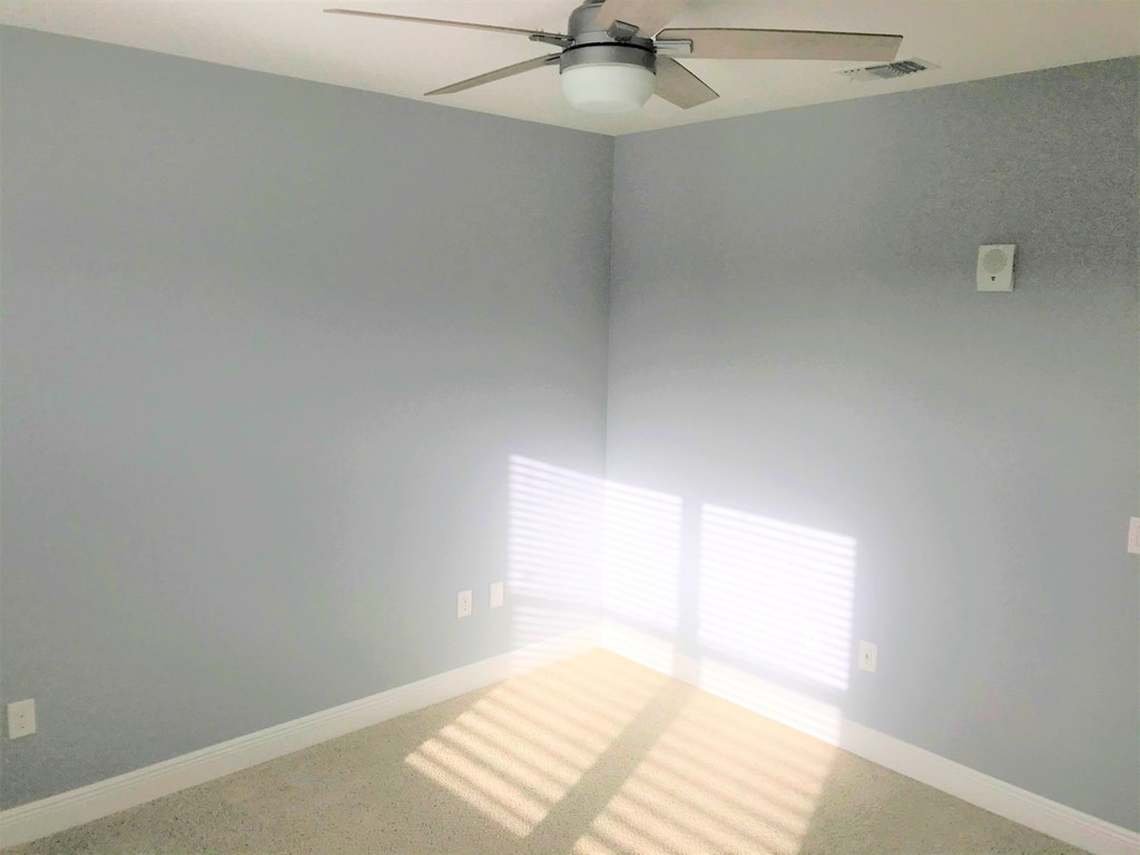 a room with blue walls and a ceiling fan