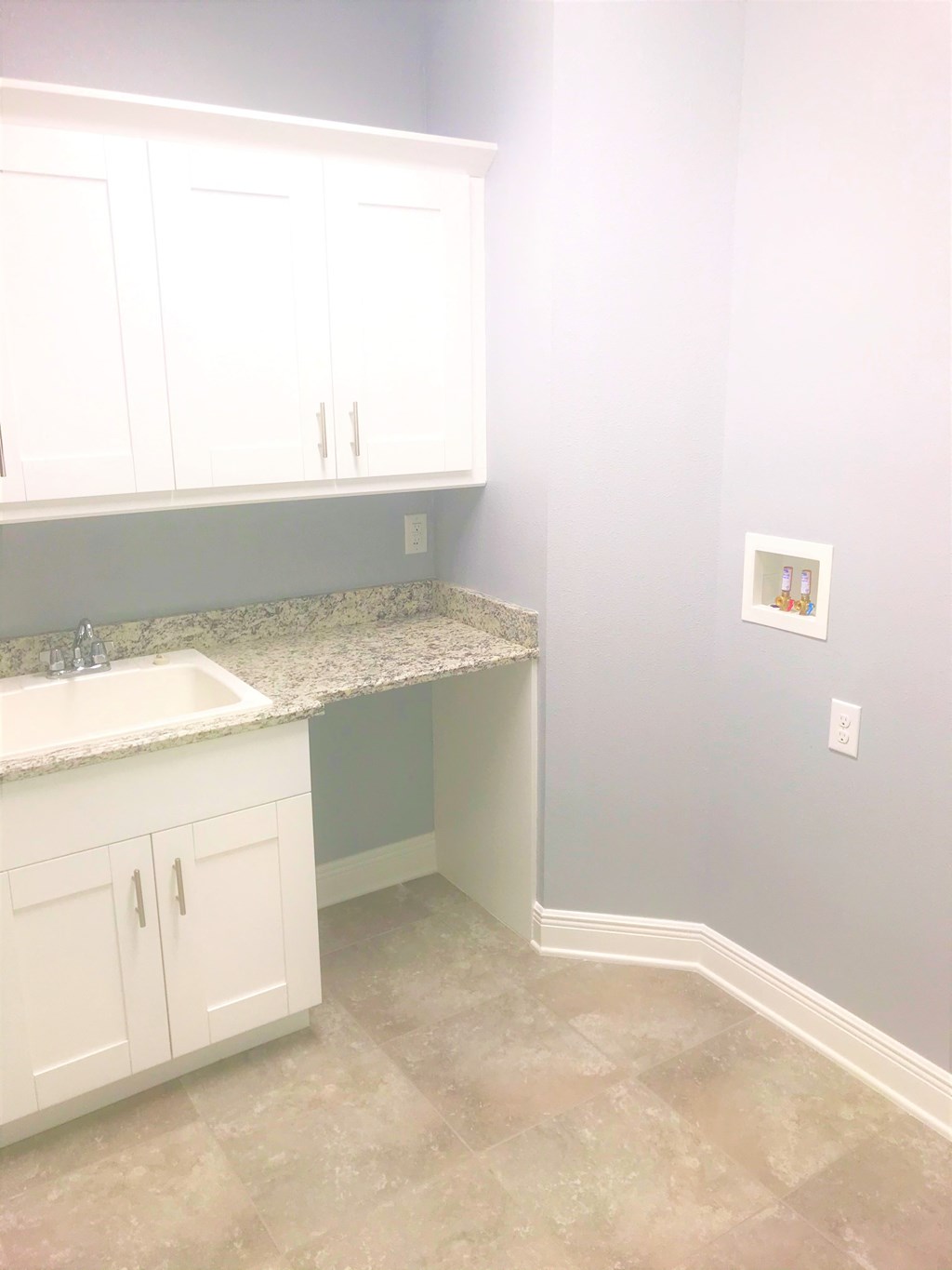 a small kitchen with white cabinets and a sink and a counter