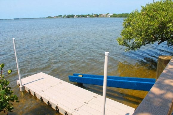 a dock with a blue bench on the water