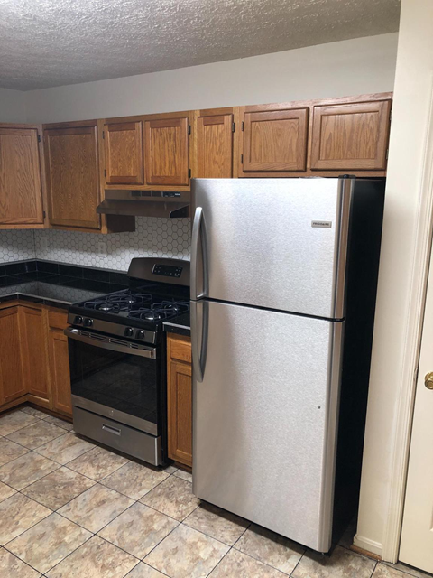 A kitchen with a stainless steel refrigerator and an oven.