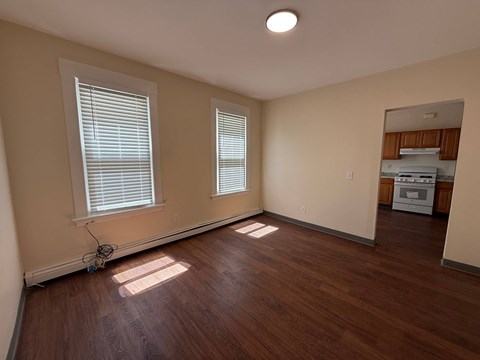 A room with wooden floors and two windows.
