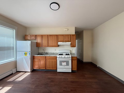 A kitchen with wooden cabinets and a white fridge.