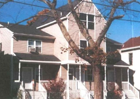 A house with a tree in front of it.