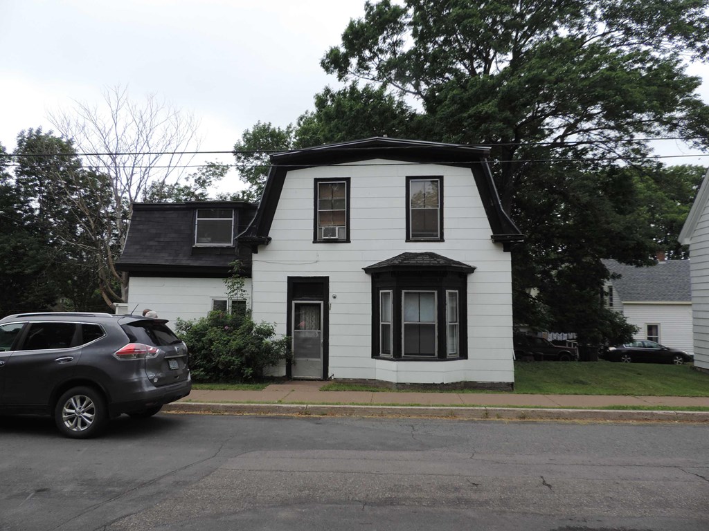a white house with a car parked in front of it