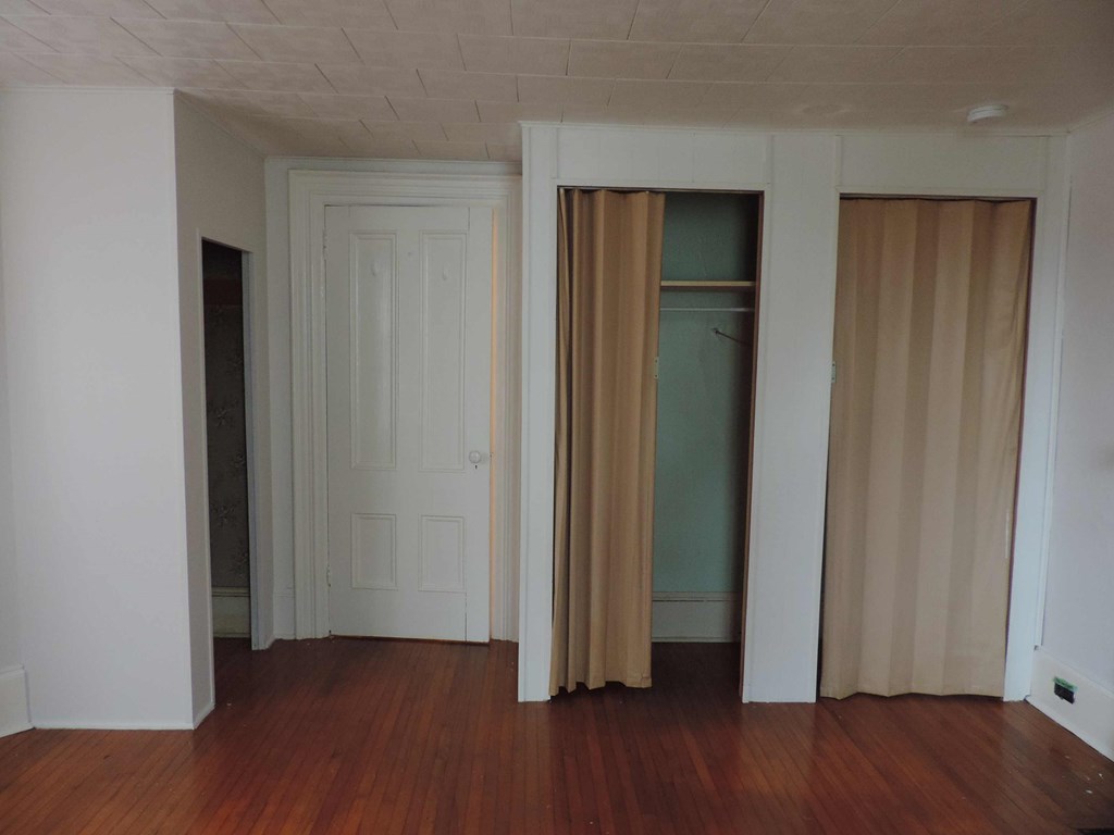a living room with wood floors and white walls and sliding doors