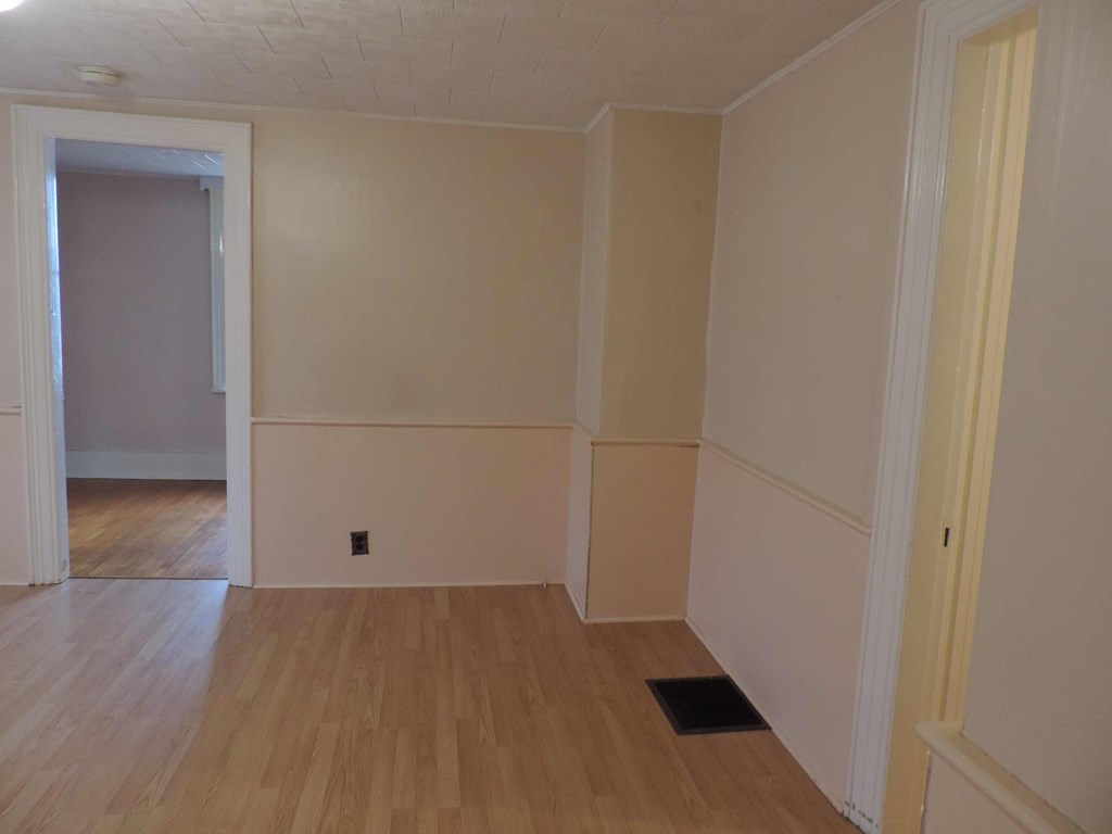 an empty room with wooden floors and white walls