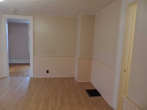 A room with wooden floors and white walls.