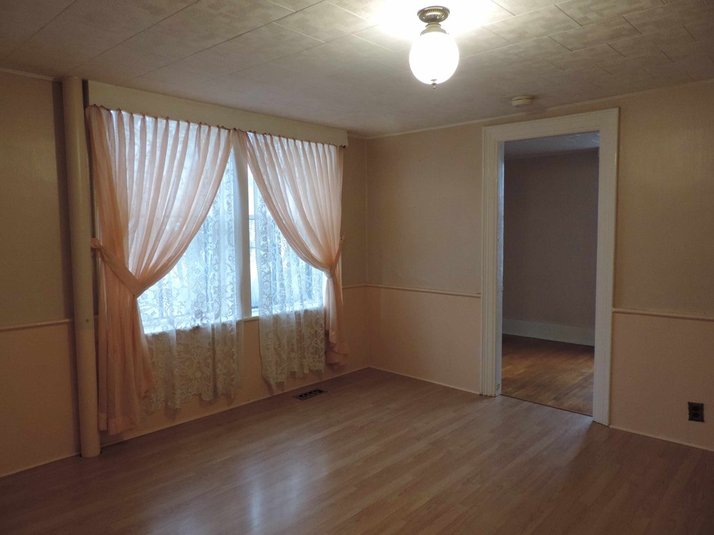 an empty living room with windows and curtains