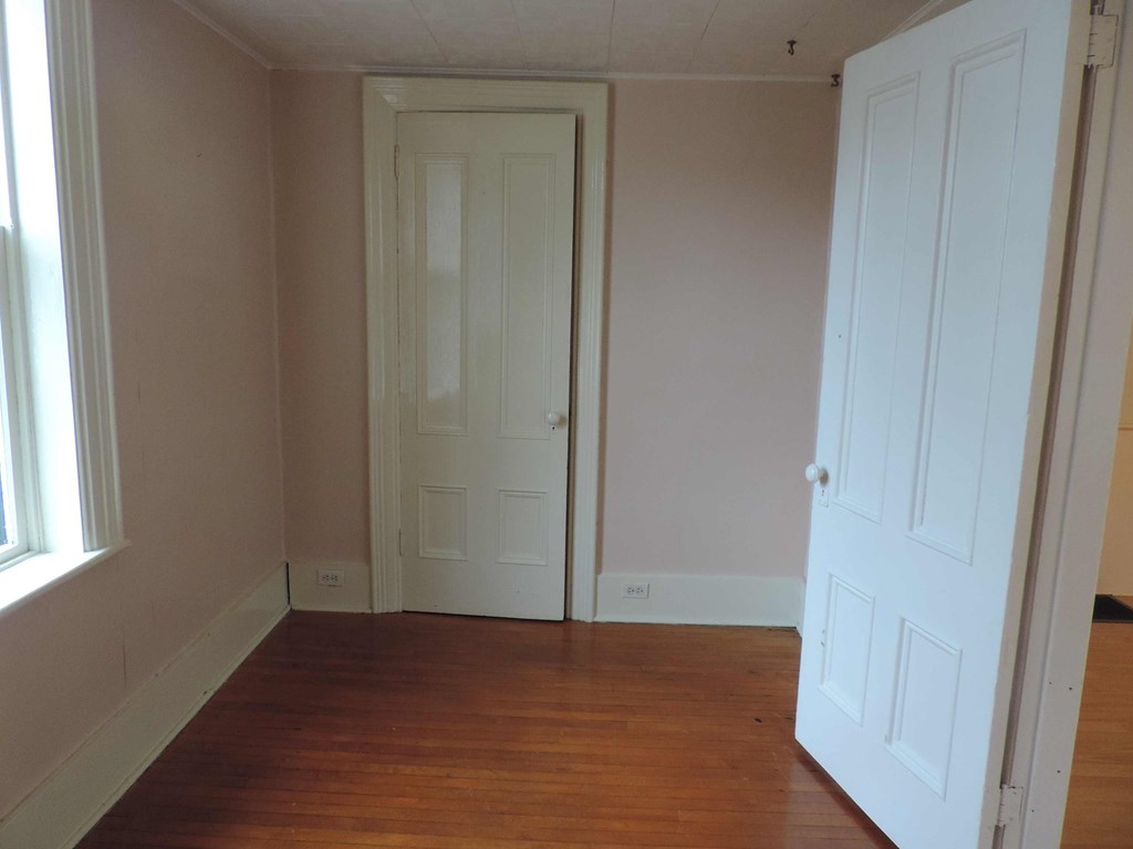 a room with a wooden floor and a white door