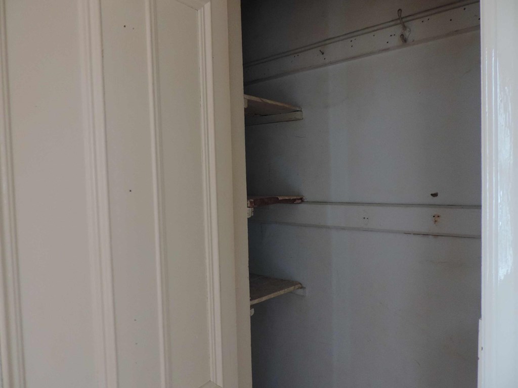 a closet with empty shelves in a white closet
