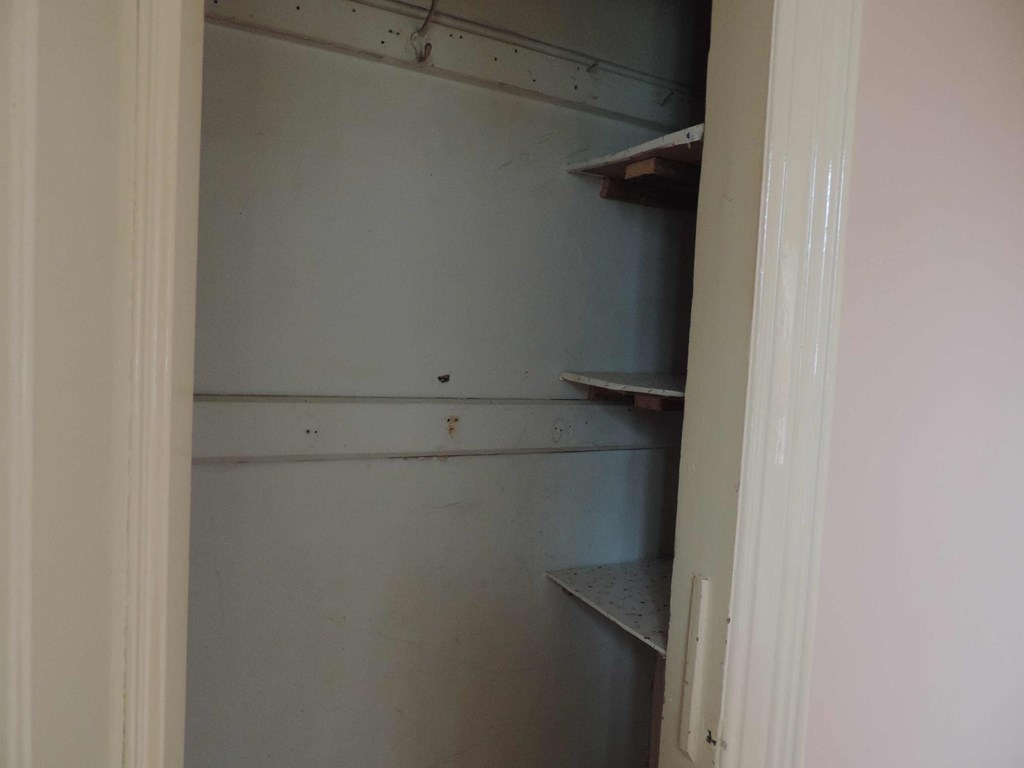 a small closet with shelves on the wall