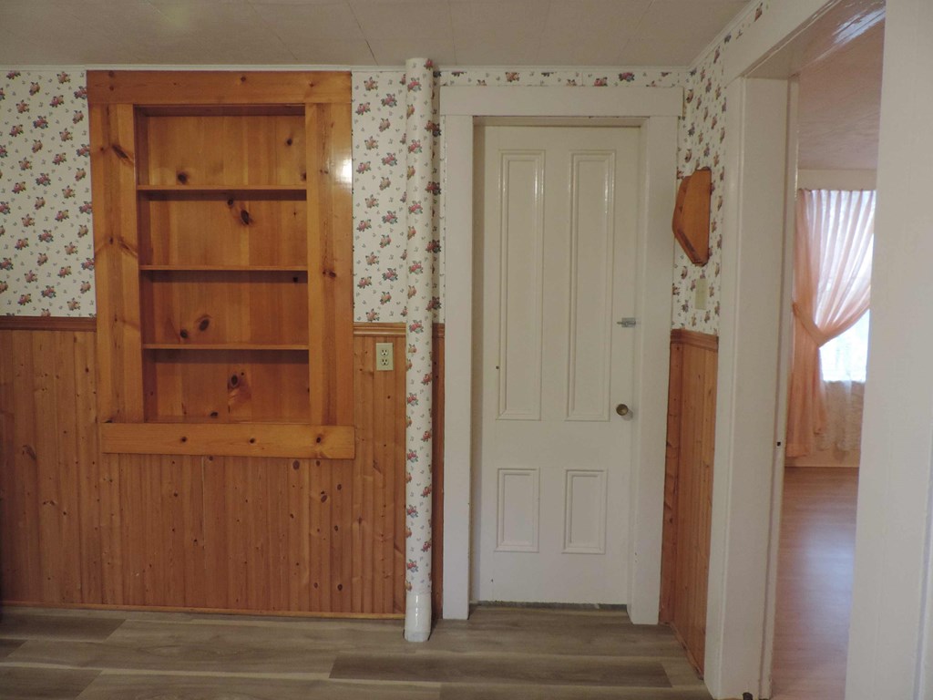 a room with a door and a shelf in it