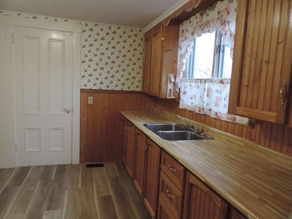 an empty kitchen with wooden cabinets and a sink