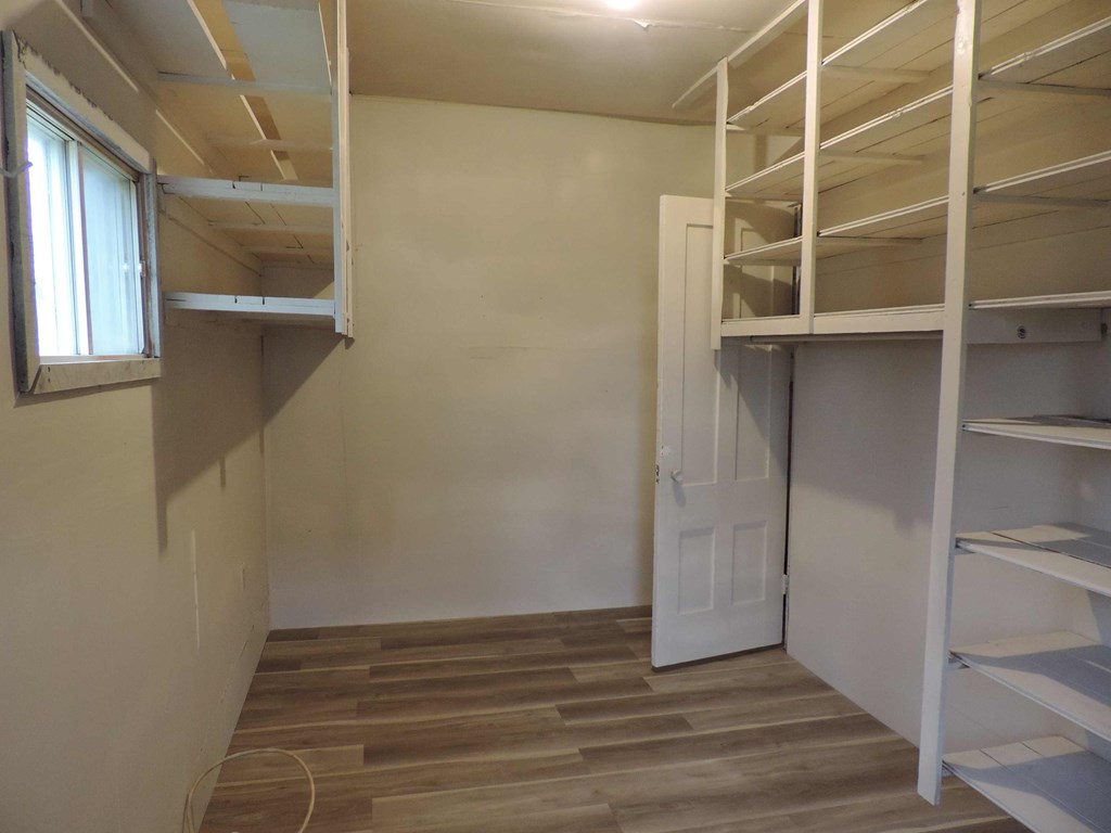 a room with shelves and a door and a closet