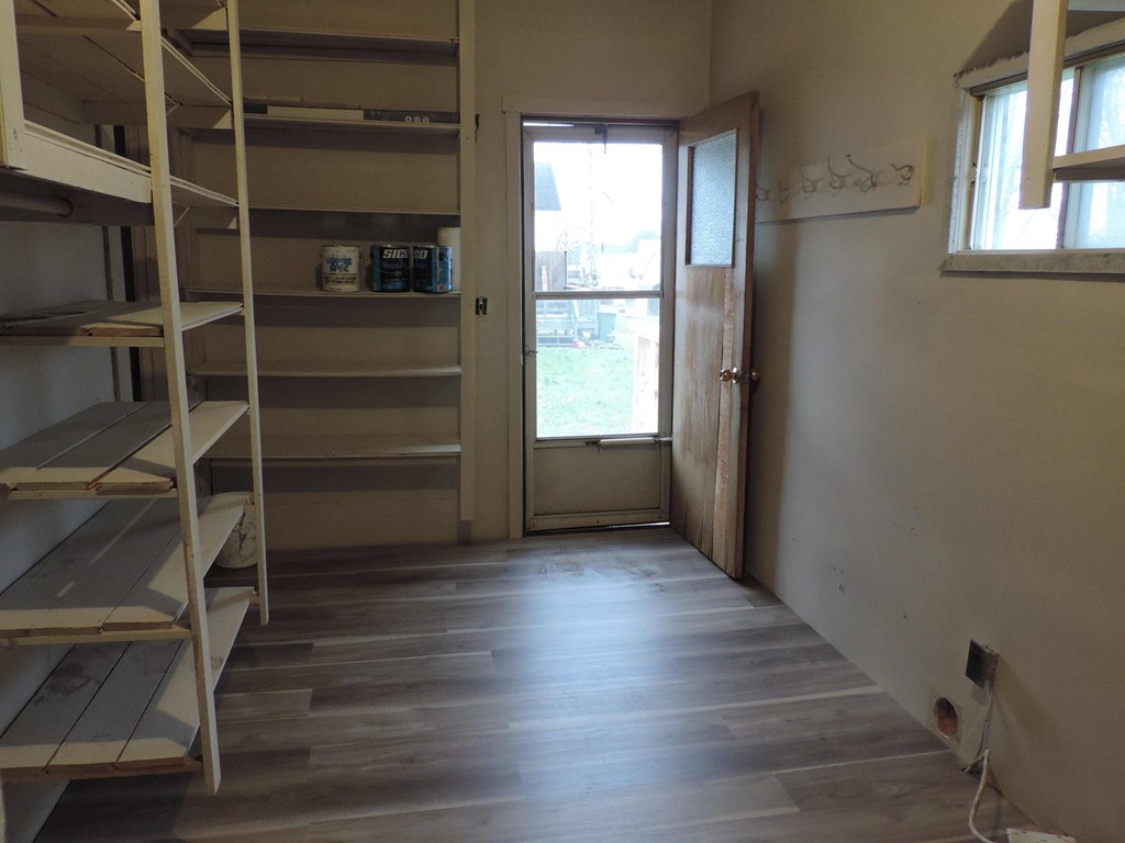 a room with shelves and a door and a window