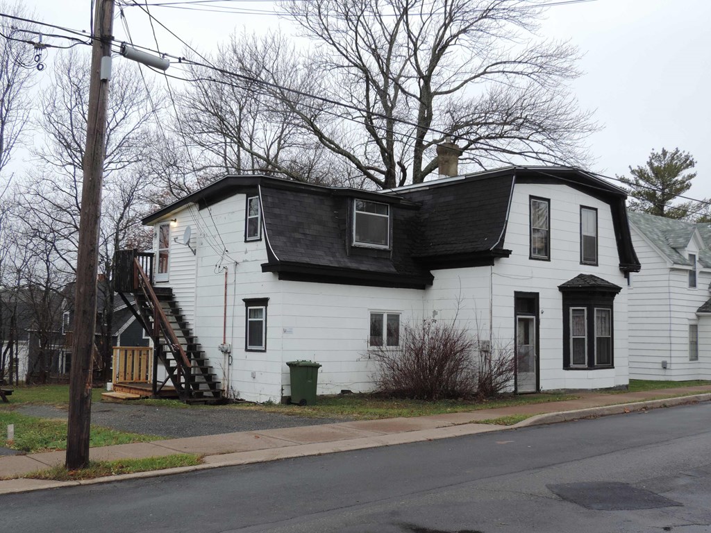 a white house with a black roof on a street