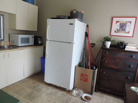 a kitchen with a refrigerator and a microwave in it