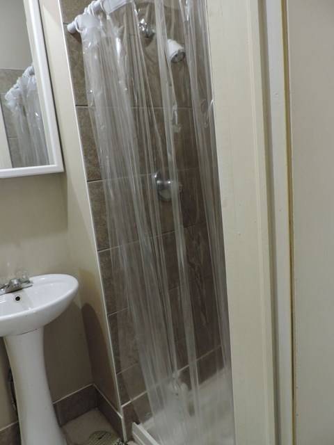 a small bathroom with a shower and a sink