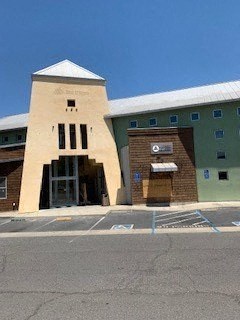 A building with a tall entrance and a small tower on top.