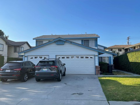 a white garage with two cars parked in front of it