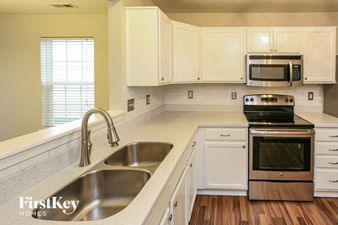 a kitchen with white cabinets and stainless steel appliances
