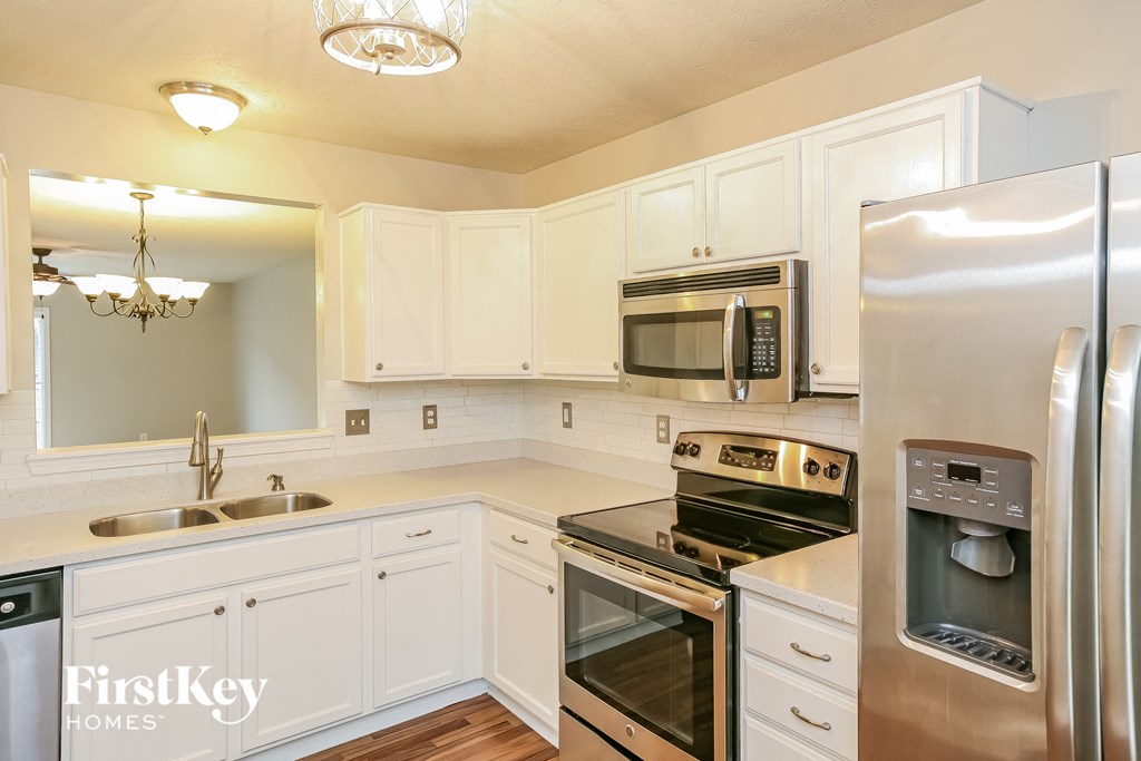 a kitchen with stainless steel appliances and white cabinets