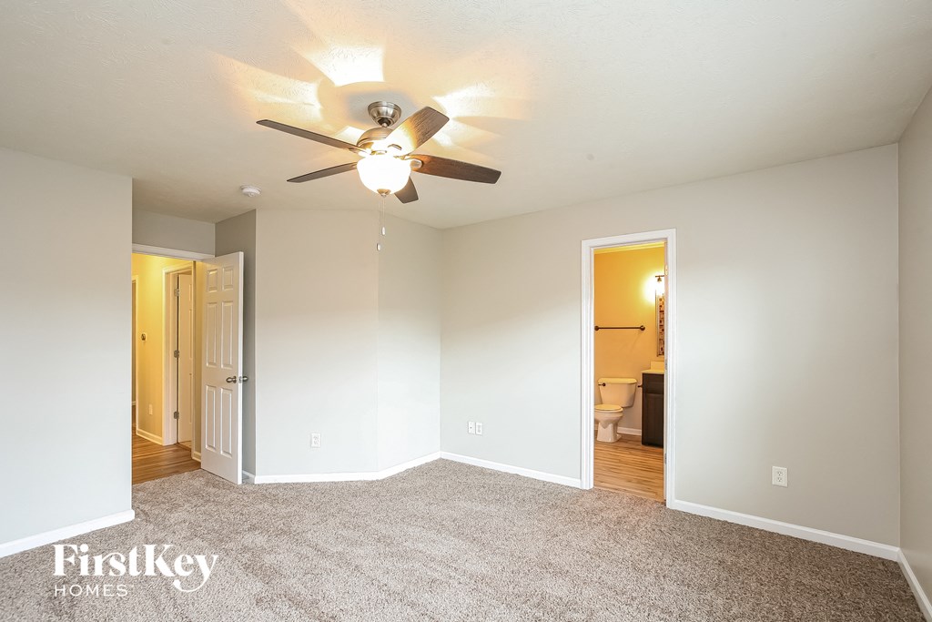 an empty living room with a ceiling fan