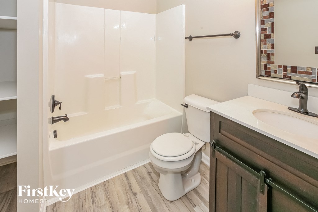 a bathroom with a toilet and a sink and a bath tub