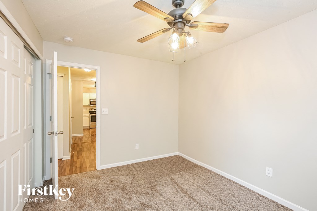 the living room of an empty house with a ceiling fan
