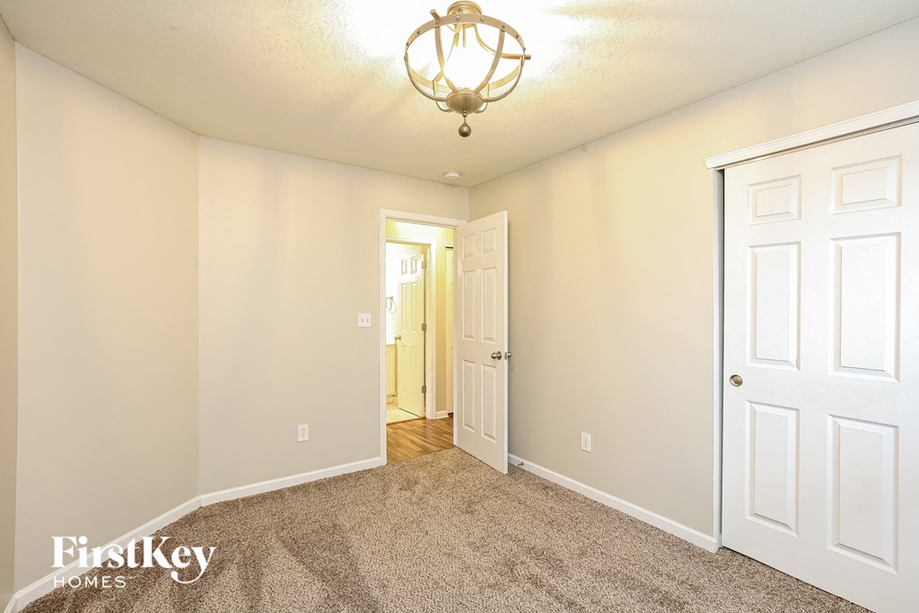 a bedroom with a closet and a door to a hallway