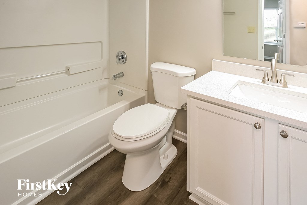 a bathroom with a toilet and a tub and a sink