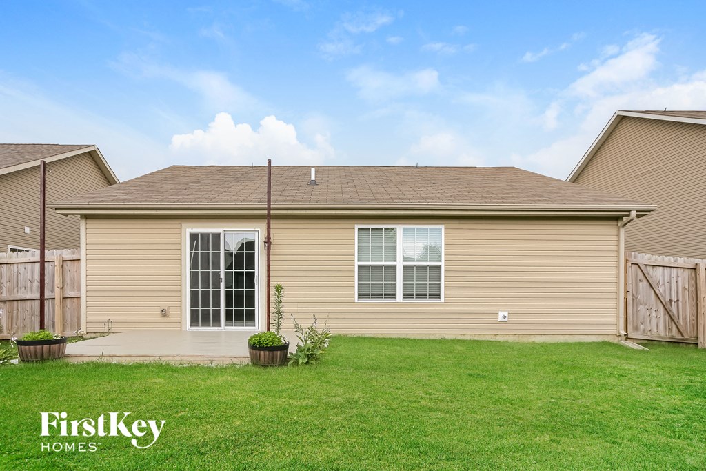 the backyard of a home with a lawn and a patio
