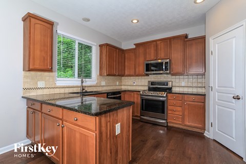 A kitchen with wooden cabinets and a black countertop.