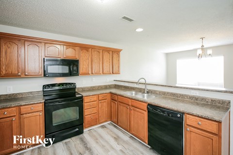 a kitchen with wooden cabinets and black appliances