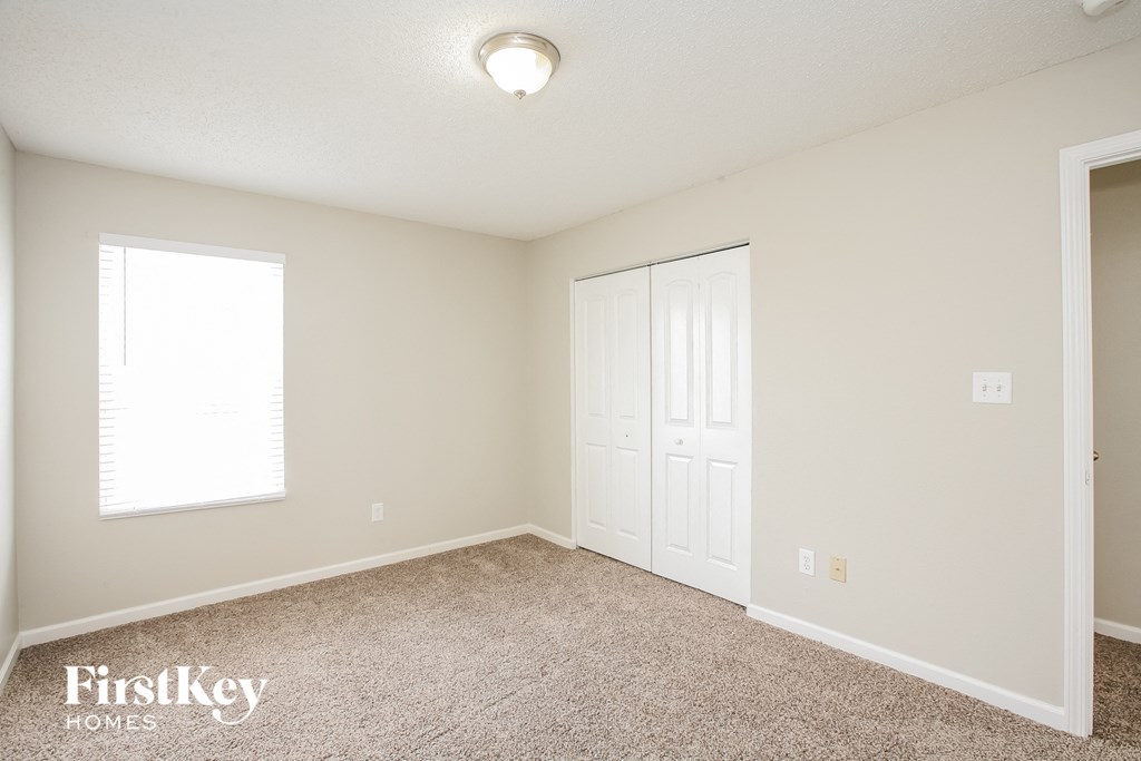 a bedroom with a closet and a door and a window