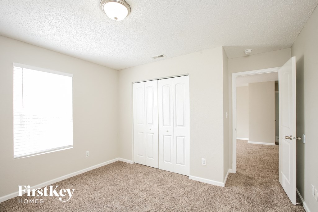 a bedroom with a closet and a door and a window