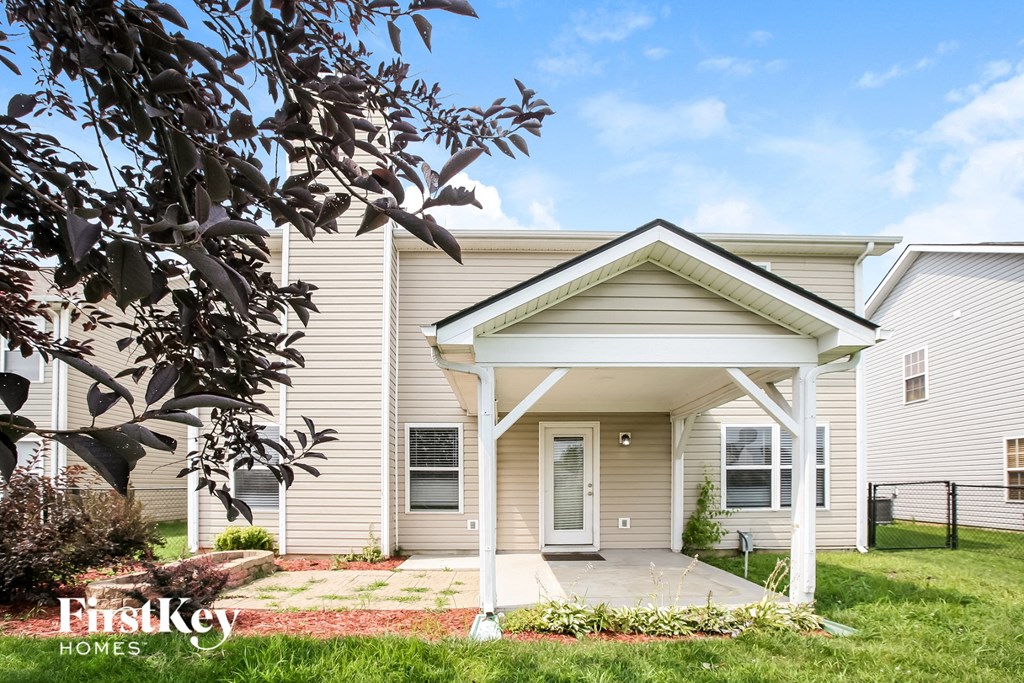 a small white house with a covered porch and a yard