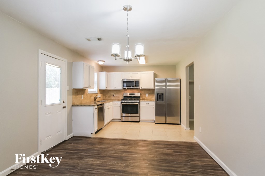 a kitchen with white cabinets and stainless steel appliances