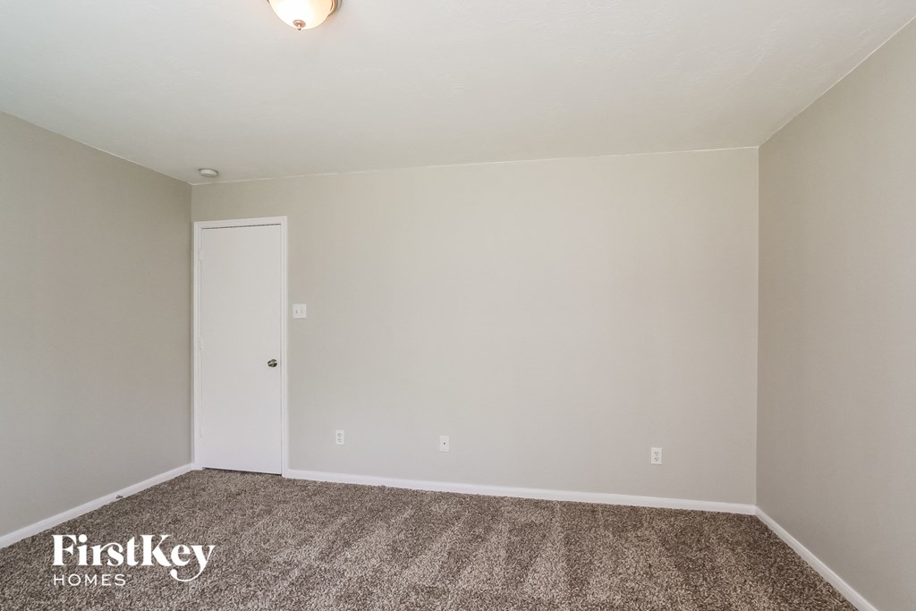 a empty room with carpet and a white door