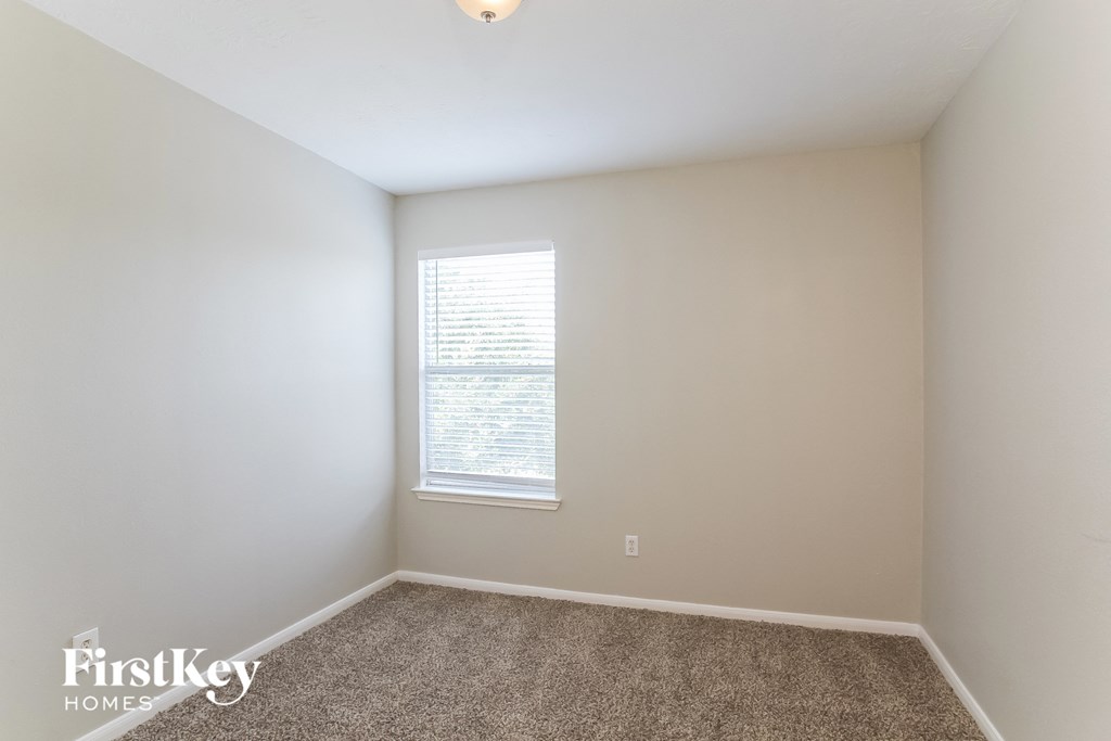 a bedroom with a carpeted floor and a window